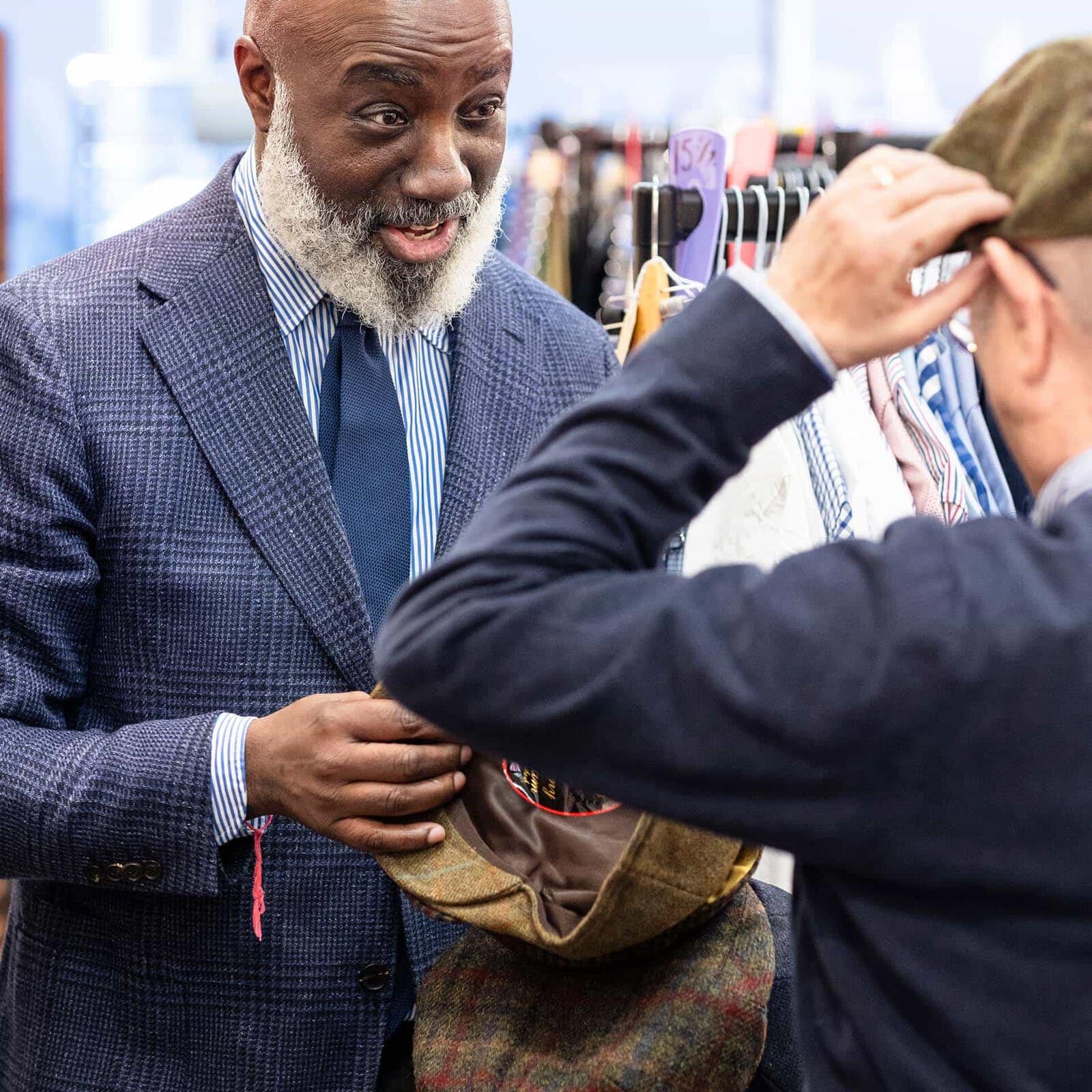 Lo stylist Paul aiuta un cliente a provare dei cappelli. Siamo da Suited & Booted. Fotografia di Enzo Dal Verme dal libro fotografico Un Abito Alla Volta