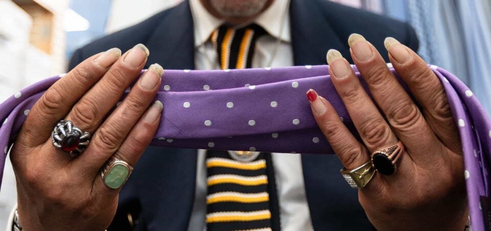 Le mani di Alfred, conosciuto anche come Mr Bling, fotografate Enzo Dal Verme. Siamo da Suited & Booted e Alfred sta scegliento una cravatta. L'immagine è parte del libro fotografico "Un abito alla volta"
